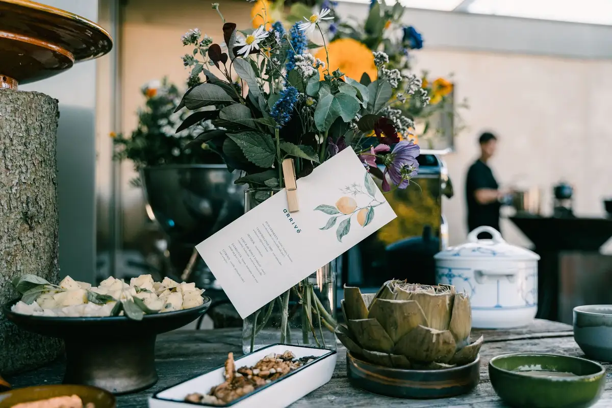 Buffet met artisjok, veldbloemen en een menukaartje met citroentak.