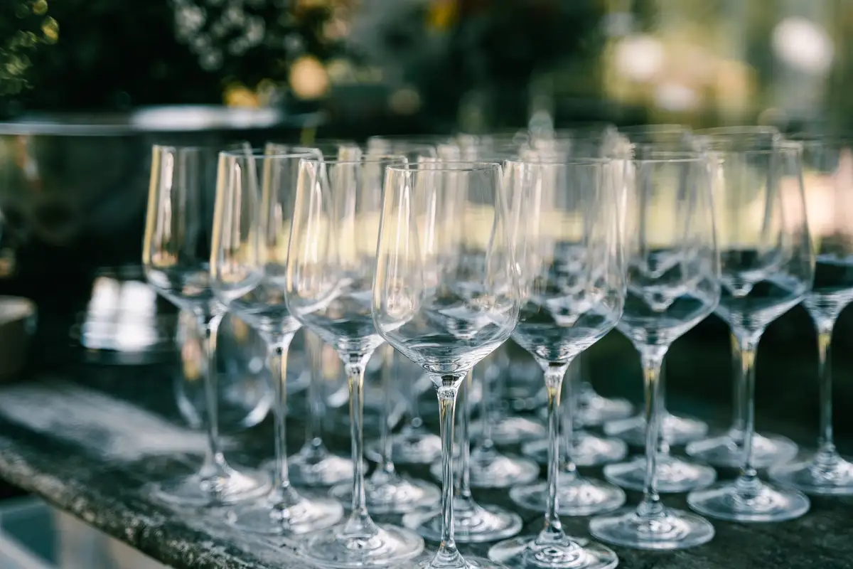 Een rij champagneglazen op een oude houten tafel.